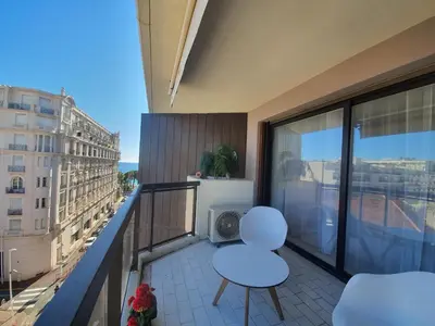a balcony with two white chairs and a view of a city at Les jardins de la Croisette 6, by Welcome to Cannes in Cannes