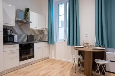 a small kitchen with a table and a window at Le Sweet Forville 2 - Palais des Festivals - Marché provençal - Plage - Clim - Au calme in Cannes