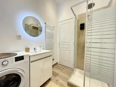a washing machine in a bathroom with a mirror at Le Sweet Forville 2 - Palais des Festivals - Marché provençal - Plage - Clim - Au calme in Cannes