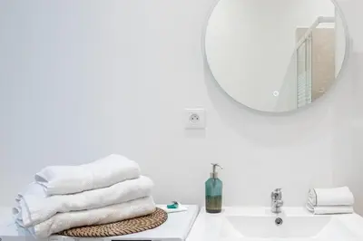 a white bathroom with a sink and a mirror at Le Sweet Forville 2 - Palais des Festivals - Marché provençal - Plage - Clim - Au calme in Cannes