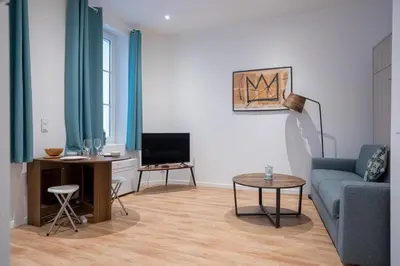 a living room with a blue couch and a tv at Le Sweet Forville 2 - Palais des Festivals - Marché provençal - Plage - Clim - Au calme in Cannes