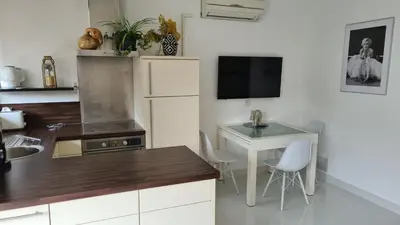 a kitchen with a desk and a table and a tv at 1 mn CROISETTE près Martinez in Cannes