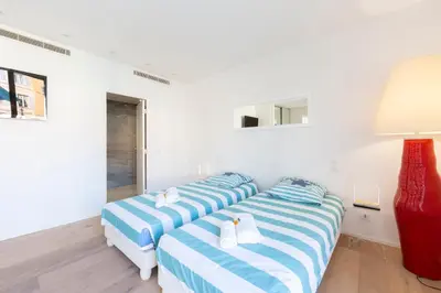 two beds in a room with white walls at Appartement 3 chambres 125 m2 avec vue exceptionnelle face à la mer in Cannes