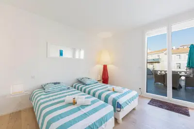 two beds in a room with a balcony at Appartement 3 chambres 125 m2 avec vue exceptionnelle face à la mer in Cannes