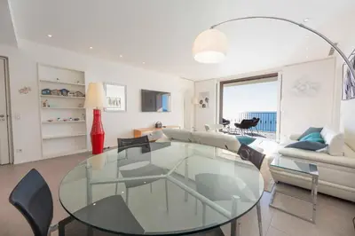 a living room with a glass table and chairs at Appartement 3 chambres 125 m2 avec vue exceptionnelle face à la mer in Cannes