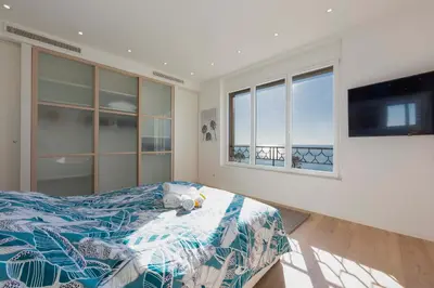 a bedroom with a bed and a flat screen tv at Appartement 3 chambres 125 m2 avec vue exceptionnelle face à la mer in Cannes