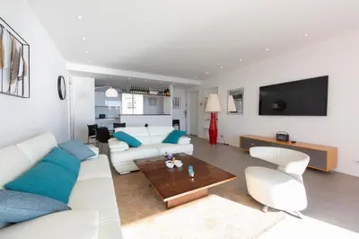 a living room with a white couch and a table at Appartement 3 chambres 125 m2 avec vue exceptionnelle face à la mer in Cannes