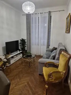 a living room with a couch and a tv at Appartement Bellarosa in Cannes
