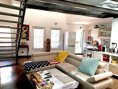 a living room with a couch and a kitchen at Le Port Luxury Loft Duplex in Cannes