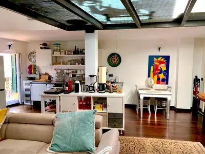 a living room with a couch and a kitchen at Le Port Luxury Loft Duplex in Cannes