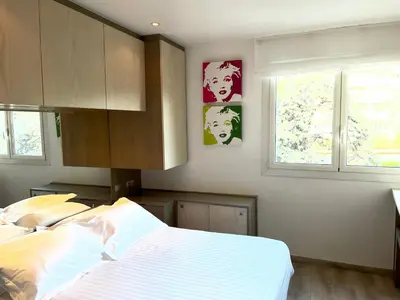a bedroom with a bed and two windows at Chambre idéalement située à 50m de la Croisette in Cannes