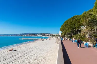 a beach with people and the ocean and a pier at Chambre idéalement située à 50m de la Croisette in Cannes