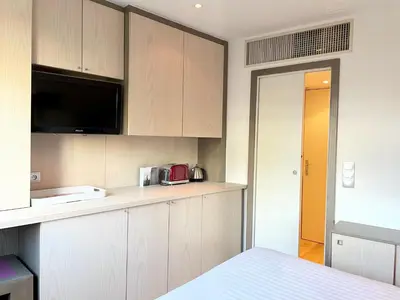 a kitchen with wooden cabinets and a counter top at Chambre idéalement située à 50m de la Croisette in Cannes