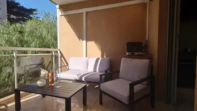 a patio with two chairs and a table on a balcony at Magnifique appartement à 10mn du Palais in Cannes