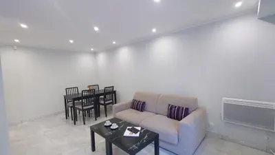 a living room with a couch and a table at Magnifique appartement à 10mn du Palais in Cannes