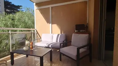 a patio with two chairs and a table on a balcony at Magnifique appartement à 10mn du Palais in Cannes