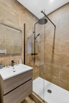 a bathroom with a sink and a shower with a glass door at 3 chambres - Marché Forville - Proche du Palais in Cannes
