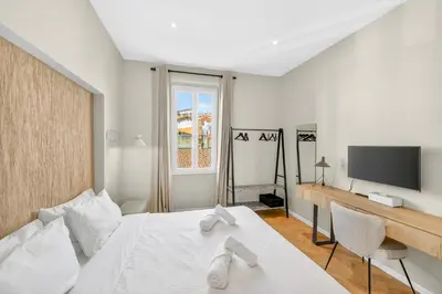 a bedroom with a bed and a desk and a tv at 3 chambres - Marché Forville - Proche du Palais in Cannes
