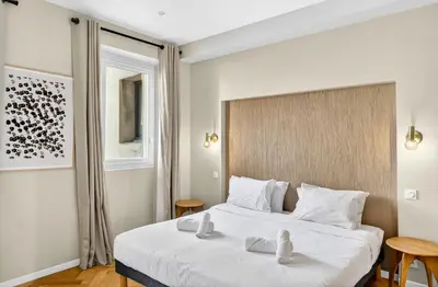 a bedroom with a bed with two towels on it at 3 chambres - Marché Forville - Proche du Palais in Cannes