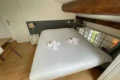 a bed with two pillows on it in a room at Riouffe 2 bedroom duplex apartment in the center of Cannes in Cannes