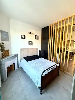 a bedroom with a bed and a desk and a window at APPARTEMENT WOOD DESING PROCHE CANNES in Le Cannet