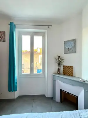 a living room with a fireplace and a window at APPARTEMENT WOOD DESING PROCHE CANNES in Le Cannet
