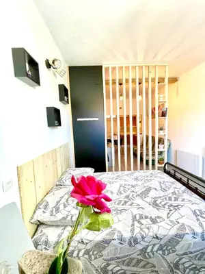 a room with a bed with a pink flower on it at APPARTEMENT WOOD DESING PROCHE CANNES in Le Cannet