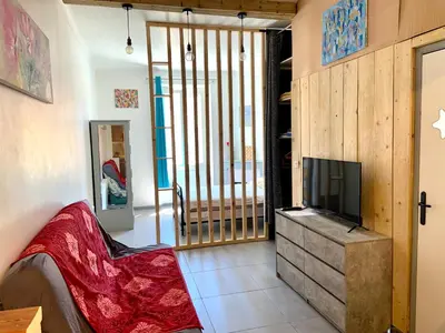 a living room with a tv on a dresser at APPARTEMENT WOOD DESING PROCHE CANNES in Le Cannet