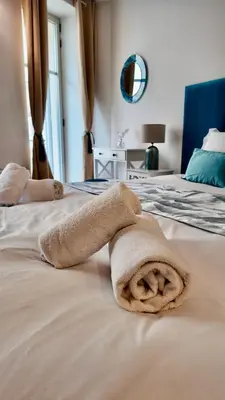 a towel is laying on a bed at LB Vacation Rentals I Large Superieure Room with Balcony I Casa d'Azur in Cannes