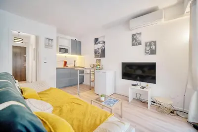 a living room with a couch and a flat screen tv at Le Kate-500m Plage-Terrasse Verrière Côte d’Azur in Cannes