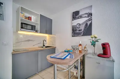 a kitchen with a table and a car on the wall at Le Kate-500m Plage-Terrasse Verrière Côte d’Azur in Cannes