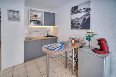 a kitchen with a table and a car on the wall at Le Kate-500m Plage-Terrasse Verrière Côte d’Azur in Cannes