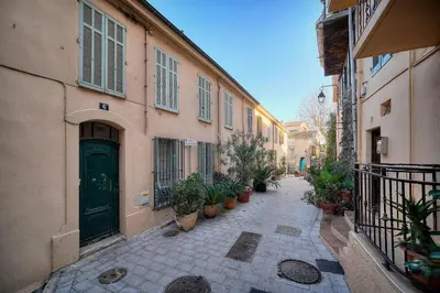 an alley with potted plants and a green door at IMMOGROOM - Refurbished - Suquet - Sea view in Cannes