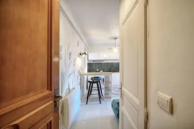 a hallway leading to a kitchen with a table at IMMOGROOM - Refurbished - Suquet - Sea view in Cannes
