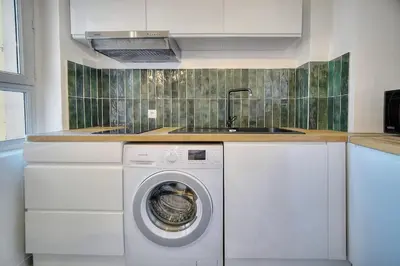 a kitchen with a washing machine and a sink at IMMOGROOM - Refurbished - Suquet - Sea view in Cannes