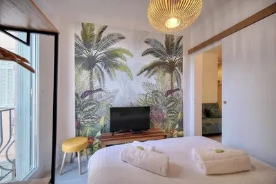 a bedroom with a bed and a tv on a wall at IMMOGROOM - Refurbished - Suquet - Sea view in Cannes