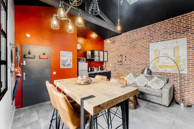 a dining room with a table and a brick wall at Magnifique Loft industriel, forville, centre de Cannes  in Cannes