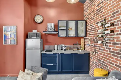 a kitchen with blue cabinets and a brick wall at Magnifique Loft industriel, forville, centre de Cannes  in Cannes