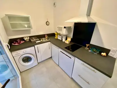 a small kitchen with a washing machine and a microwave at PAUL DOUMER #1 By SCLS Locations in Le Cannet