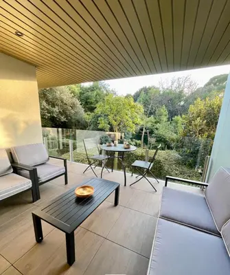 a patio with a table and chairs and a large window at Oxford 1-bedroom apartment in a new building with pool and parking in Cannes