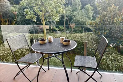 a table with two chairs and a table with cups on it at Oxford 1-bedroom apartment in a new building with pool and parking in Cannes