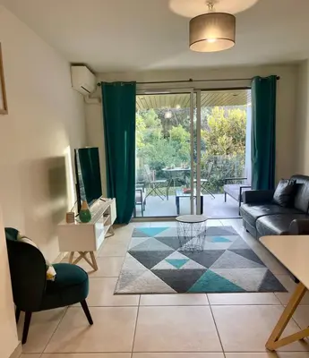 a living room with a couch and a tv at Oxford 1-bedroom apartment in a new building with pool and parking in Cannes