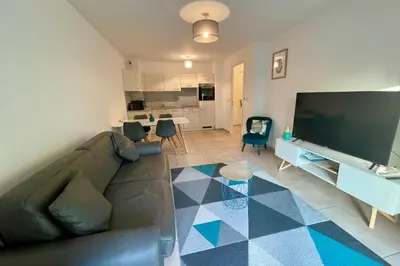 a living room with a couch and a large screen tv at Oxford 1-bedroom apartment in a new building with pool and parking in Cannes