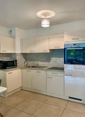 a kitchen with white cabinets and a sink at Oxford 1-bedroom apartment in a new building with pool and parking in Cannes