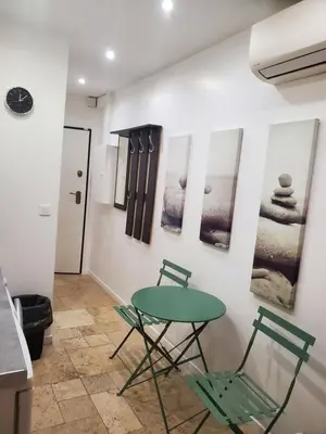 a table and chairs in a kitchen with pictures on the wall at STUDIO CENTRE CANNES FORVILLE in Cannes