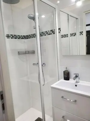 a white bathroom with a shower and a sink at STUDIO CENTRE CANNES FORVILLE in Cannes