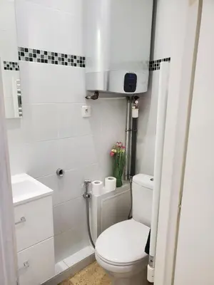 a white bathroom with a toilet and a sink at STUDIO CENTRE CANNES FORVILLE in Cannes
