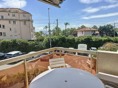 a balcony with a table and chairs and a building at 2 bedroom apartment with parking 3 mins from La Croisette beach in Cannes