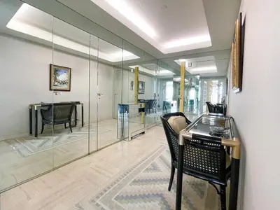 a room with glass walls and a table and chairs at 2 bedroom apartment with parking 3 mins from La Croisette beach in Cannes