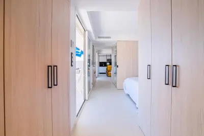 a hallway with wooden cabinets and a bed in a room at 1-Br Apartment Sea View Terrace & Parking in Cannes